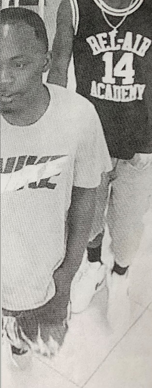 Gray surveillance photo of first suspect wearing a NIKE t-shirt. 